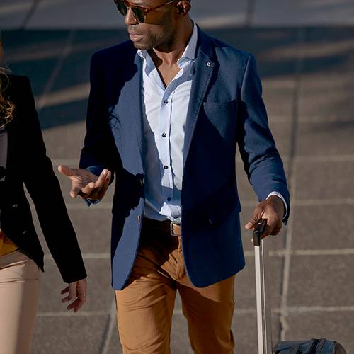 Three men walking in the street with suitcases