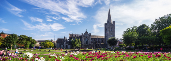 A flower garden with a historical building