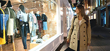 Woman out shopping looking at the mannequins in the storefront