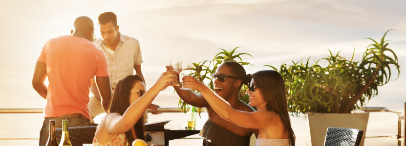 Friends enjoying drinks on a seaside patio