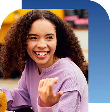 Girl holding taco and smiling