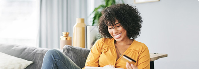 Woman sitting on the couch using her card