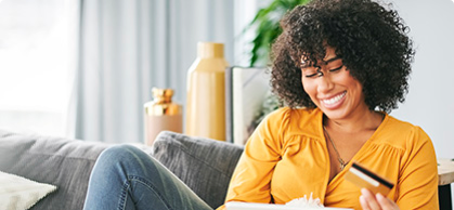 Woman sitting on the couch using her card