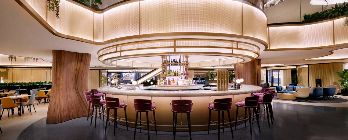 Sapphire Lounge at LaGuardia Airport, New York, with a circular bar counter, high stools, and warm lighting.