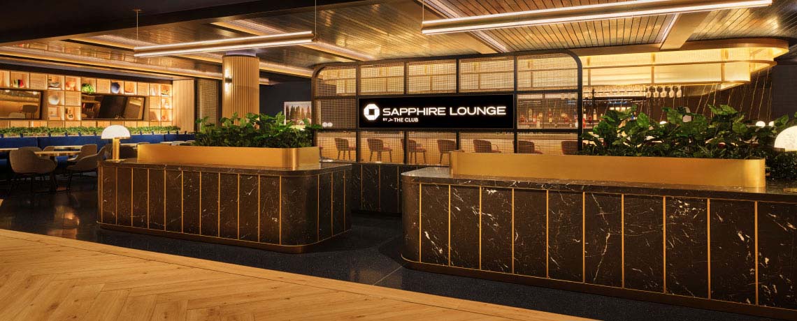 Sapphire Lounge at Philadelphia International Airport with a long bar counter, high chairs, elegant lighting, and plush seating areas.