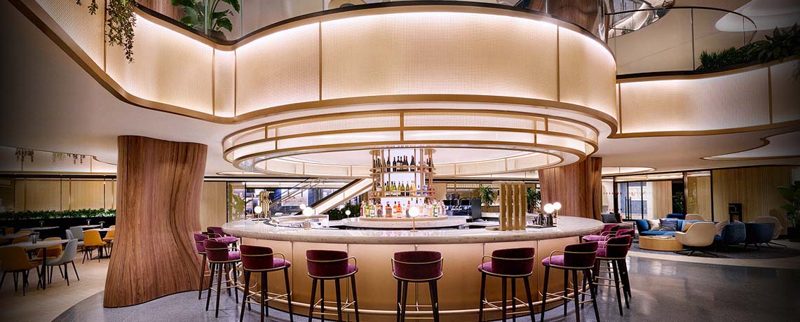 Sapphire Lounge at LaGuardia Airport, New York, with a circular bar counter, high stools, and warm lighting.