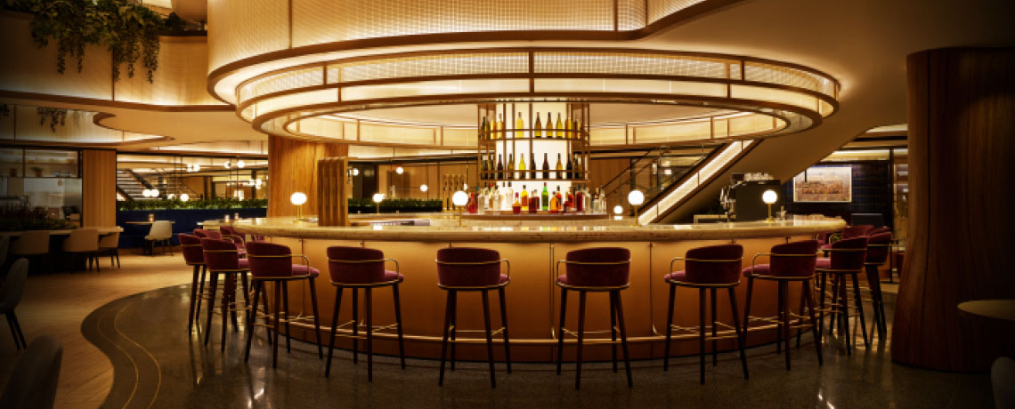 Sapphire Lounge at LaGuardia Airport, New York, with a circular bar counter, high stools, and warm lighting.