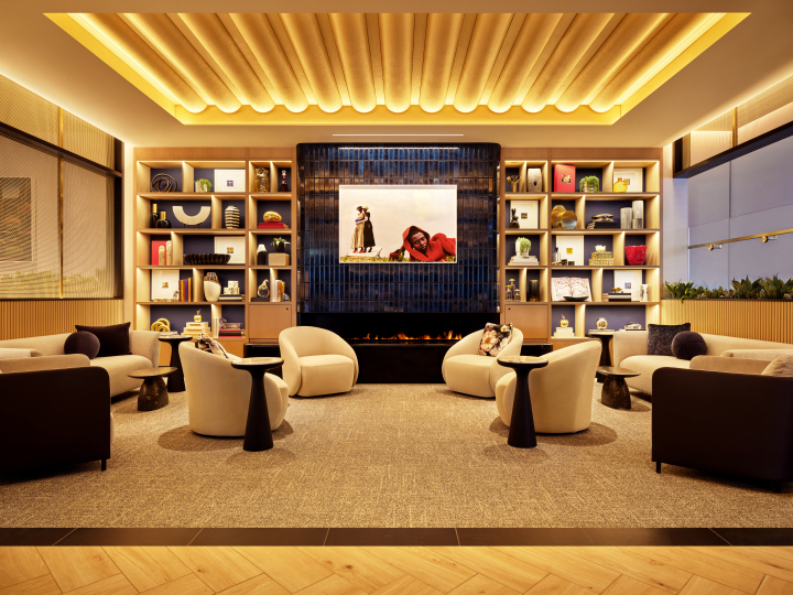 Reception area of the Sapphire Lounge at Hong Kong International Airport with a sleek stone desk, gold bars, and the lounge logo.
