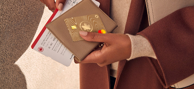 Close up shot of a passenger holding her Air Canada card and boarding pass
