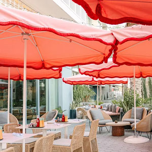 Outdoor dining area with umbrellas at Kimpton Rowan Palm Springs