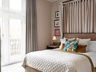 Guest room interior at Kimpton Fitzroy London with bed and window seating