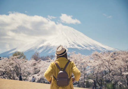 A hiker looking at Mt. Fuji behind cherry blossoms in Tokyo, Japan
