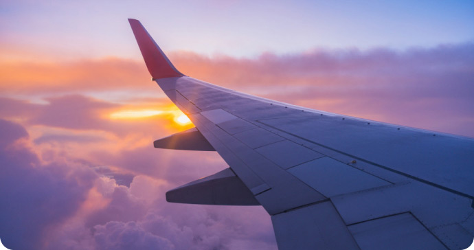 View of airplane wing above clouds