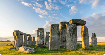 Stonehenge at sunrise under a blue sky