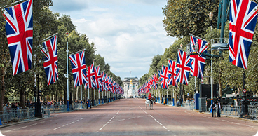 The Mall leading to Buckingham Palace, lined with Union Jack flags.