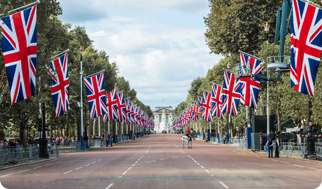 The Mall leading to Buckingham Palace, lined with Union Jack flags.