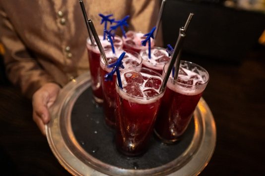 Red iced drinks with airplane stirrers on a serving tray