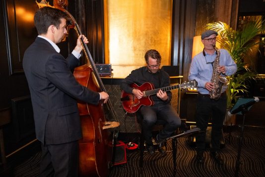 Musicians playing guitar, cello, and saxophone
