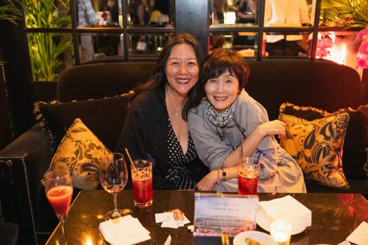 Two guests pose for photo while seated