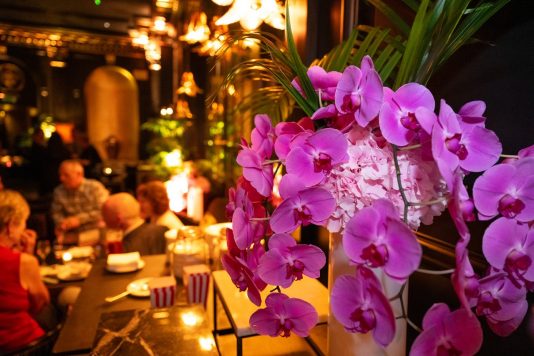 Purple orchid centerpiece at dinner event