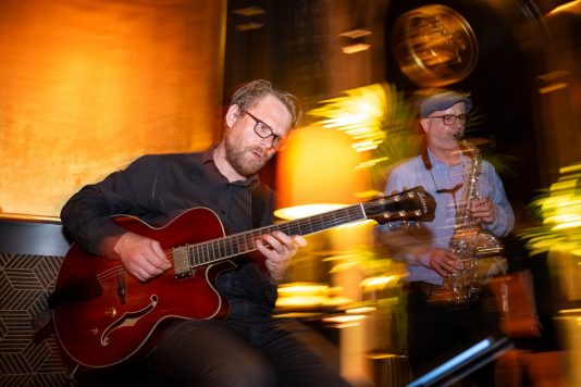 Musicians playing guitar and saxophone