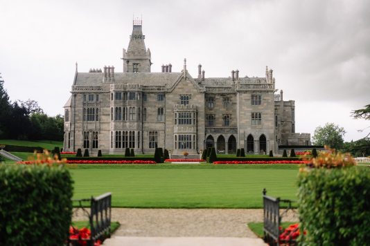 Adare Manor exterior with lawn and gardens.