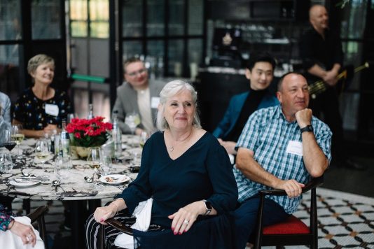 Guests seated at banquet tables indoors.