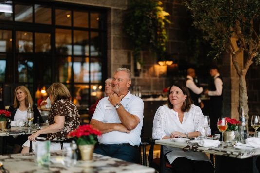 Guests seated at dinner table indoors.