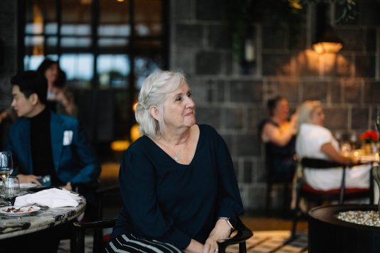 Attendee seated indoors during event.