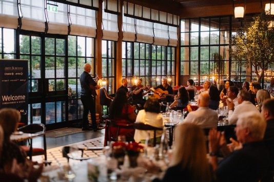 Guests seated at dinner during presentation.