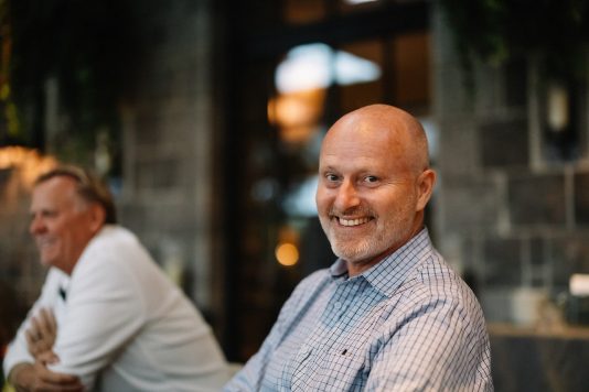 Portrait of attendee seated indoors.