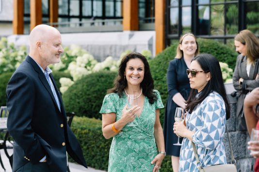 Guests conversing outdoors with drinks.