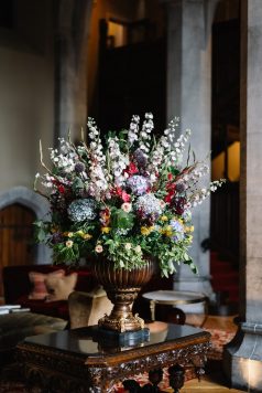 Large floral arrangement in vase inside manor.