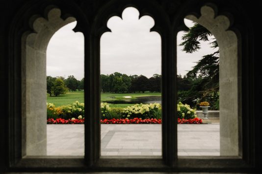 View through arched windows overlooking gardens.
