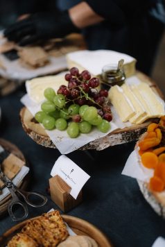 Cheese board with grapes and sliced cheeses.