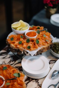 Salmon appetizer platter with lemon and garnish.
