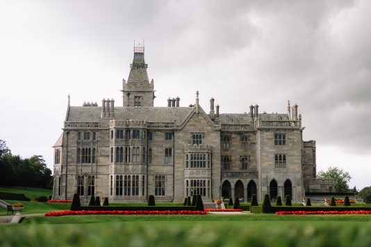 Adare Manor exterior with garden beds.