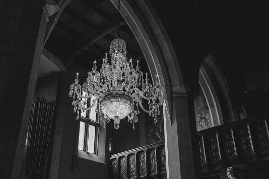 Black and white chandelier inside vaulted room.