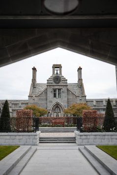 Manor building with arched entrance and clock tower.