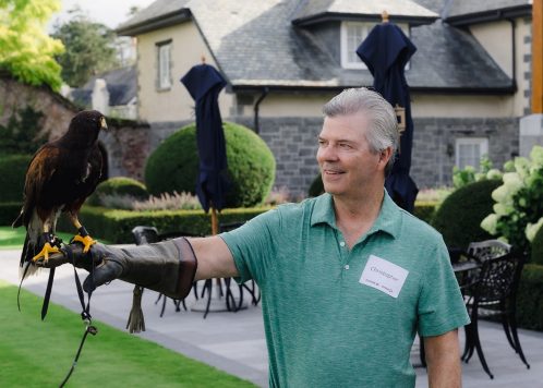 Attendee holding hawk on gloved arm.
