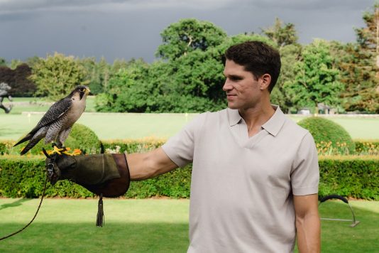 Attendee holding falcon on gloved arm.