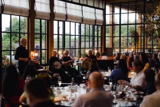 Guests seated at dinner with live music performance.
