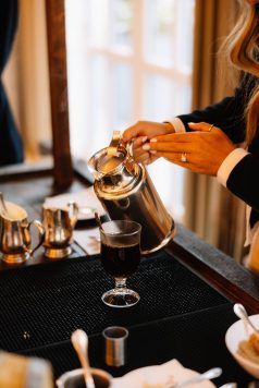 Bartender pouring drinks from a metal pitcher.