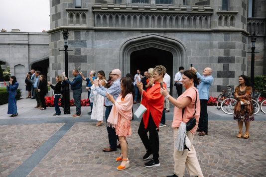 Guests gathered outside a stone manor entrance.