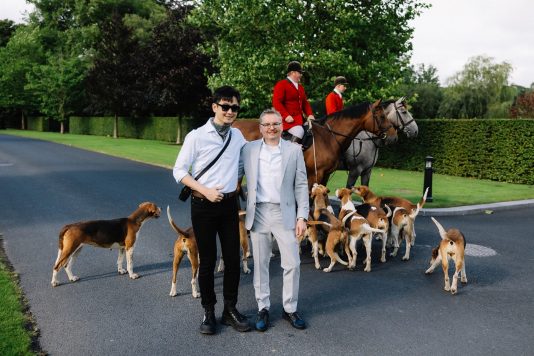 Group posing with horses and dogs.
