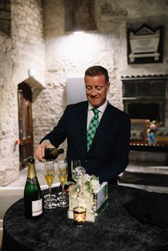 Bartender preparing drinks behind a bar.