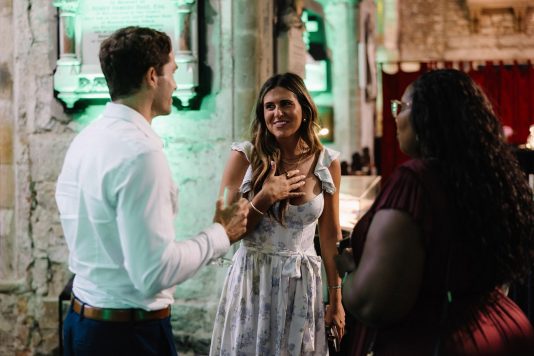 Guests chatting indoors during a reception.