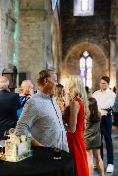 Attendees socializing inside historic stone interior.