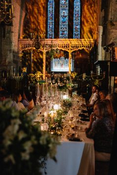 Guests dining inside a cathedral setting.