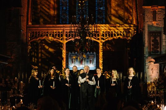 Candlelit cathedral dining scene.